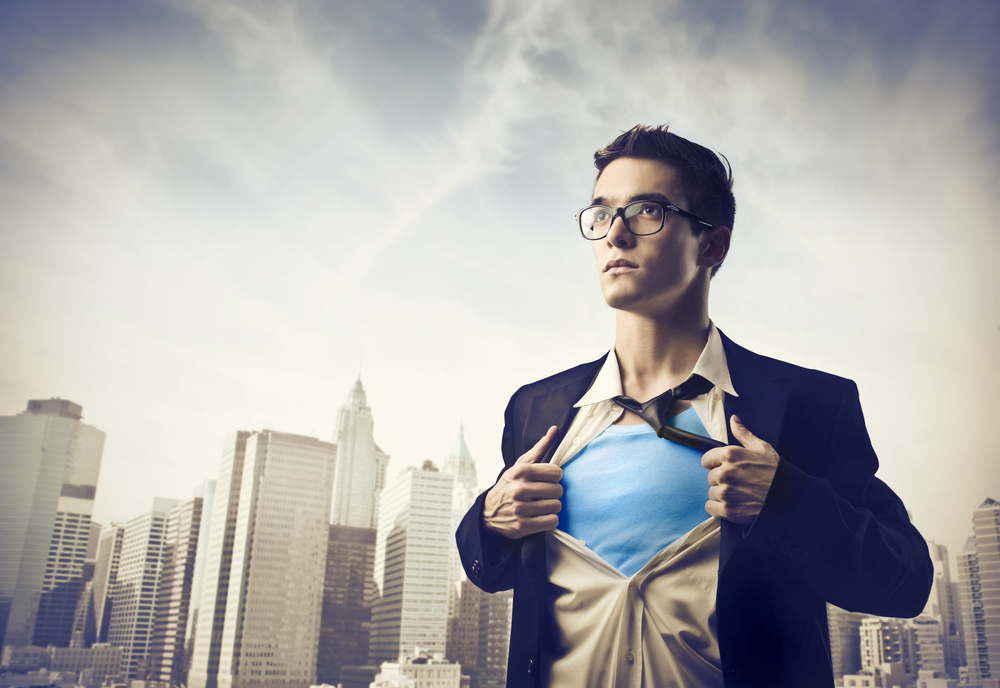 Young businessman showing the superhero suit under his shirt with cityscape in the background