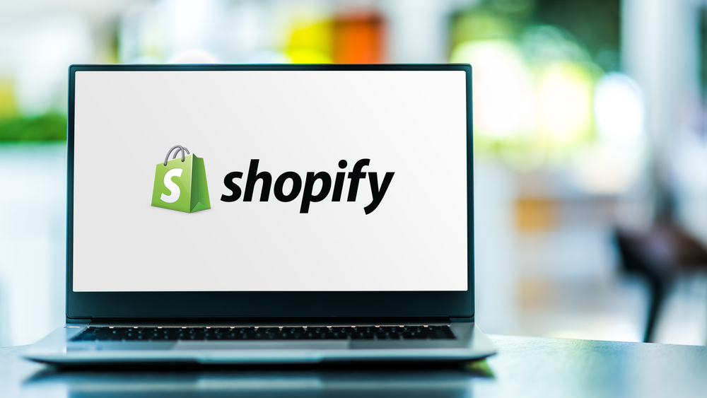 Laptop computer displaying logo of Shopify