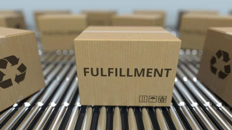 Boxes with FULLFILMENT text move on industrial roller conveyors.