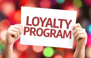 Two hands holding a sign that says "Loyalty Program".