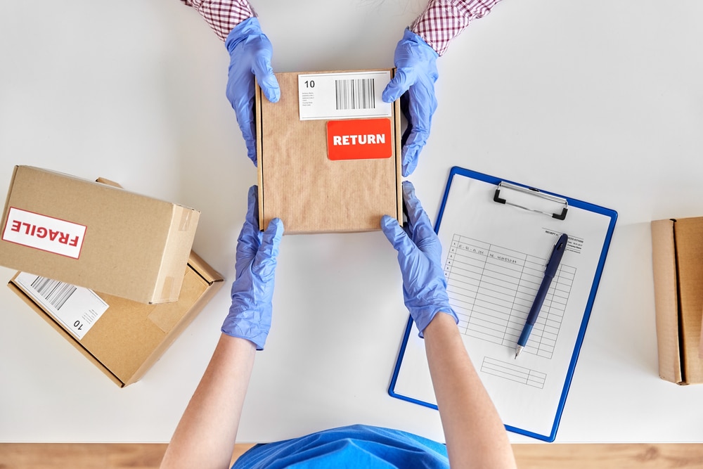 Customer returning a package. Top down view across a desk.